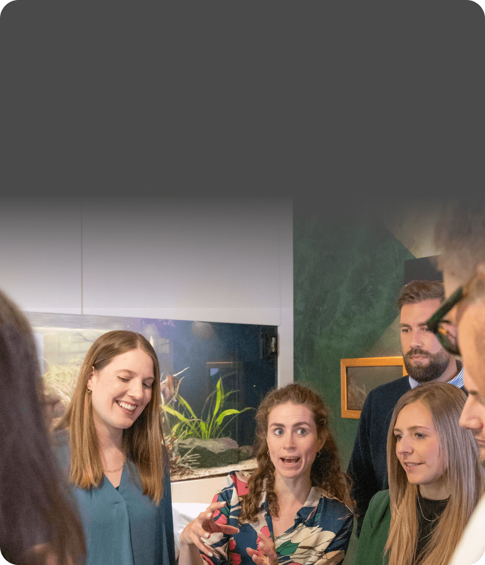Woman telling a story with lively gestures while her colleagues listen intently