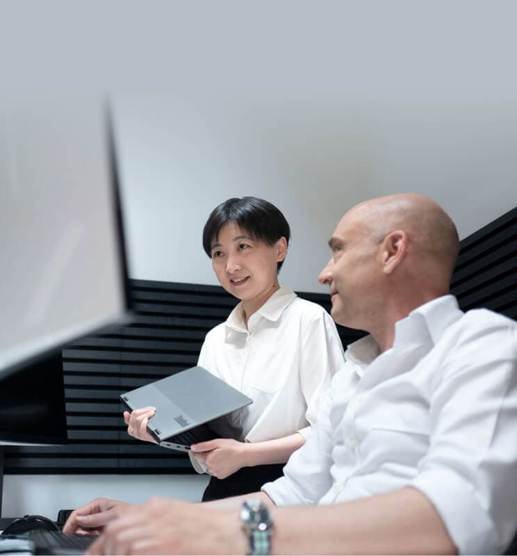 Beraterin mit Laptop und Kollege arbeiten gemeinsam an einem Bildschirm