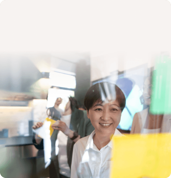 Smiling consultant behind a glass wall with colorful sticky notes
