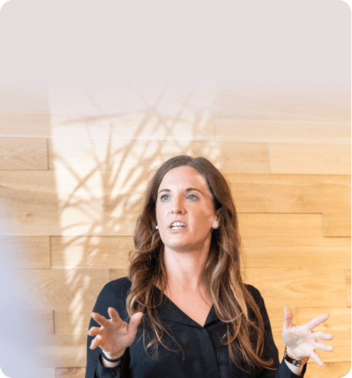 Woman explaining her thoughts with open hands in front of a wooden wall
