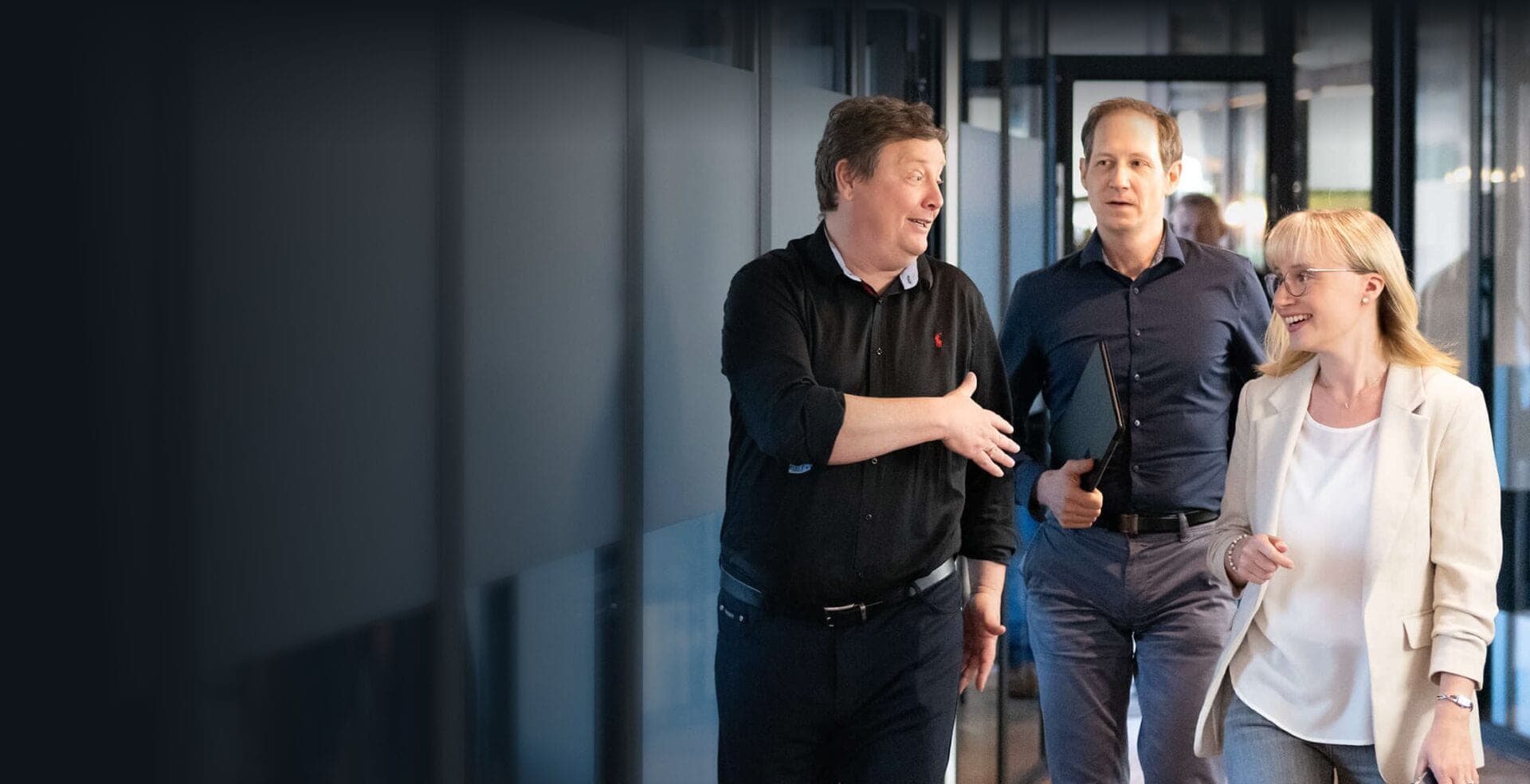 Three CPC consultants talking as they walk along an office corridor