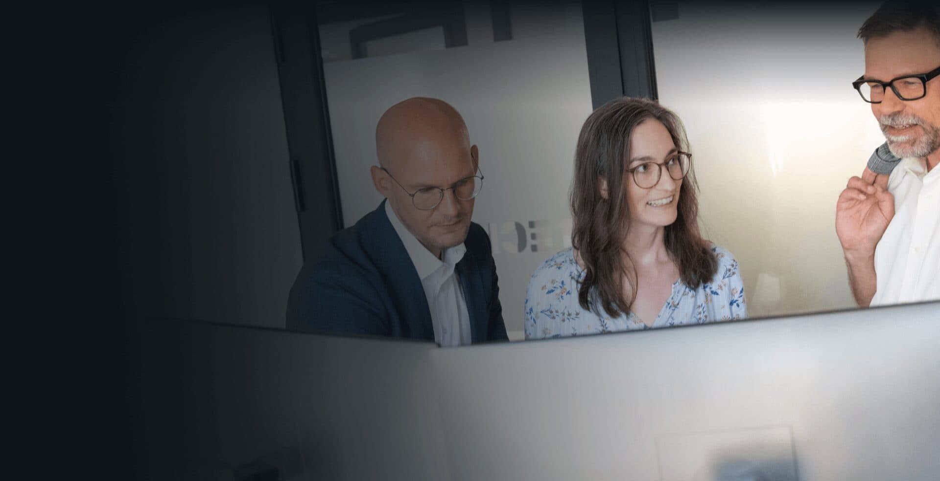 Consultants looking at a monitor together in the office and discussing the results