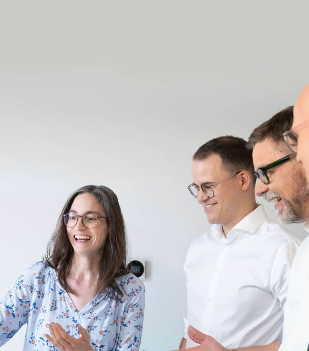 Consultant laughing as she explains a point to three colleagues