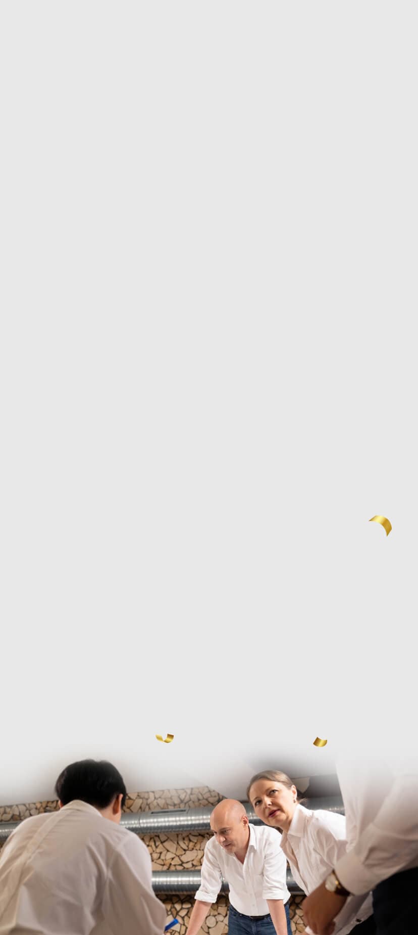 Beratende beugen sich über einen Arbeitstisch, goldenes Konfetti schwebt als Zeichen des Erfolgs durchs Bild
