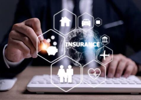 Hand tippt auf digitale Sechseck-Symbole rund um den Begriff „Insurance“