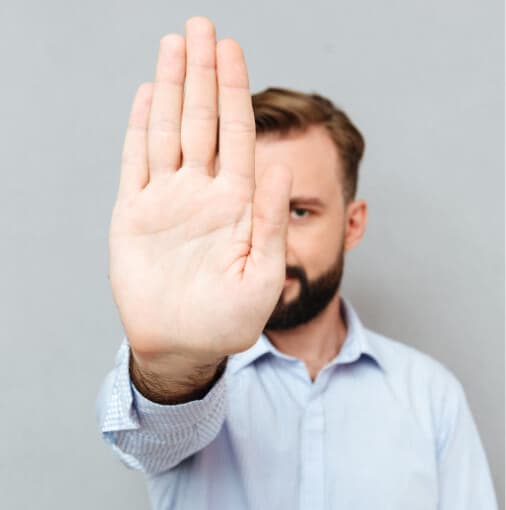 Man holding up his hand towards the camera in a stop gesture