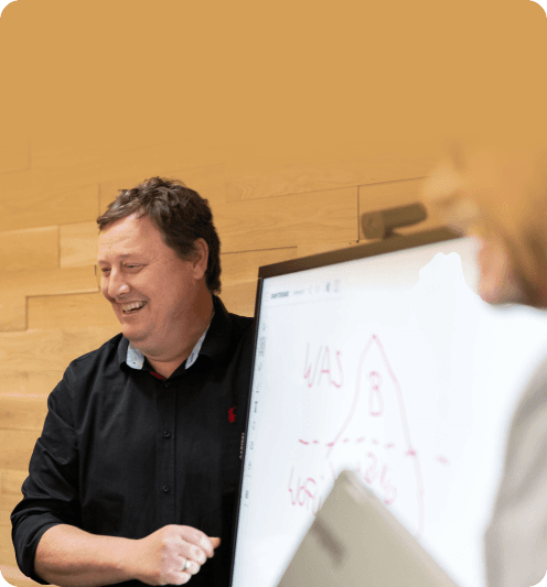 Consultant laughing in front of a whiteboard