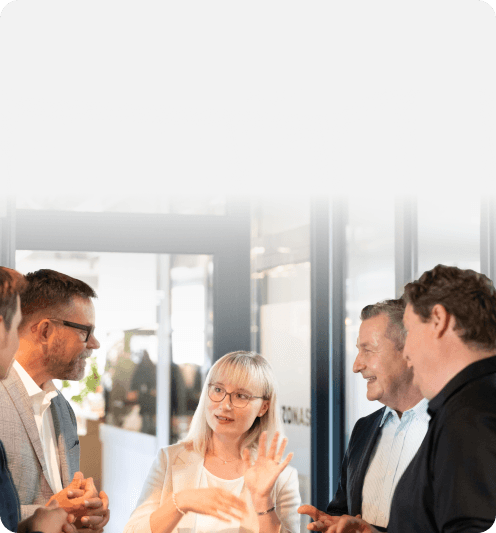 Team in conversation in an office with glass walls