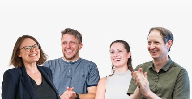 Vier Kolleginnen und Kollegen lachen und applaudieren gemeinsam