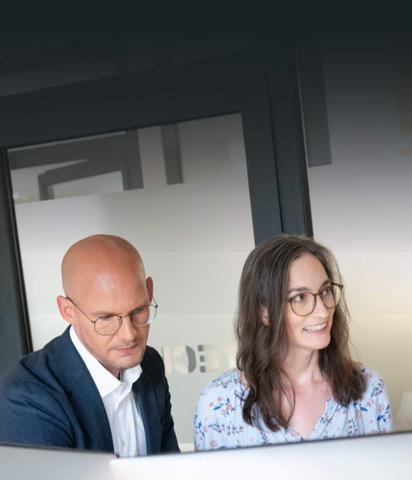 Consultants looking at a monitor together in the office and discussing the results