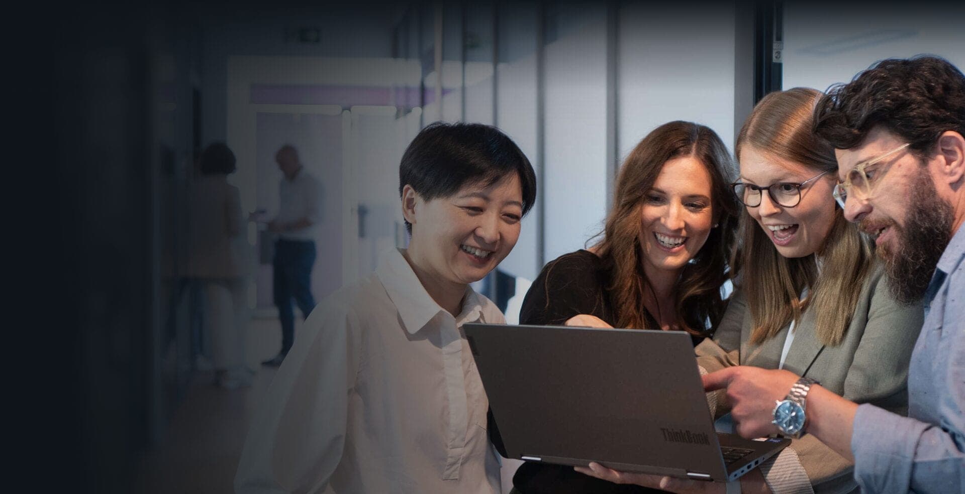 Four consultants looking at a laptop together with enthusiasm