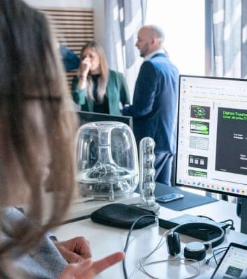Arbeitsplatz mit Monitor, auf dem eine Präsentation zur digitalen Transformation läuft
