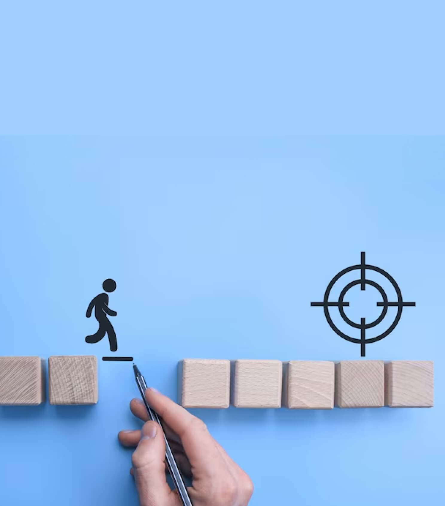 Wooden figure walking across wooden blocks towards a target symbol
