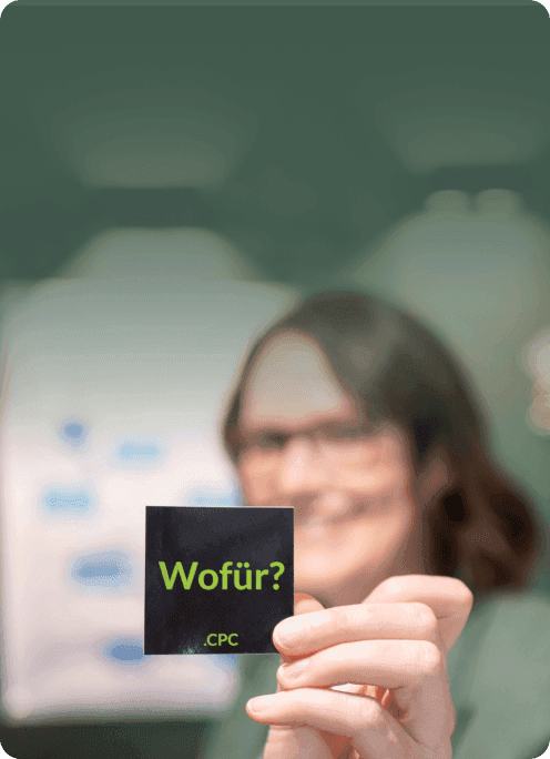 Consultant holding up a card reading “Wofür?” – German for “What for?”